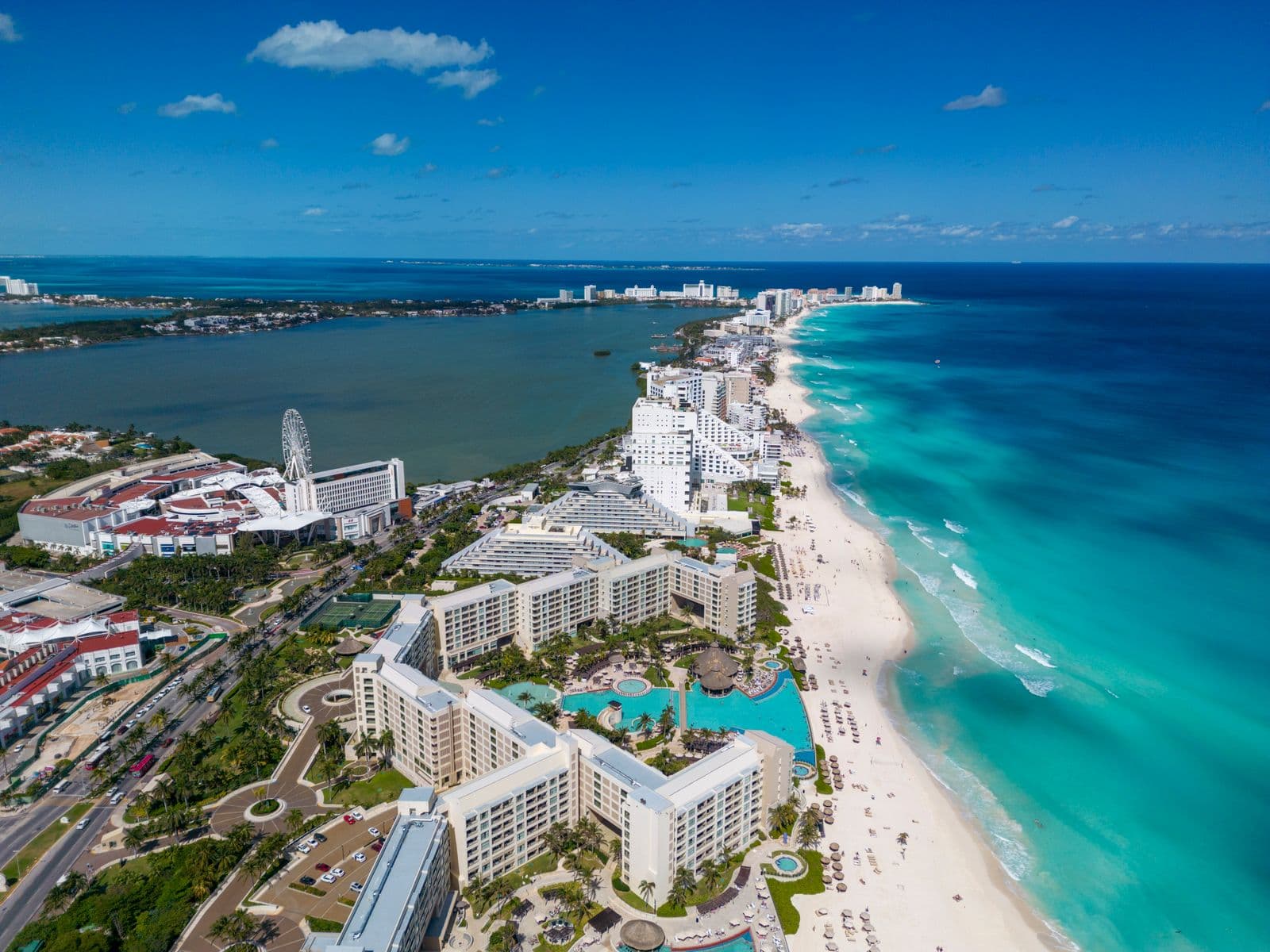 Aerial view of a turquoise Caribbean coastline lined with resorts in Mexico