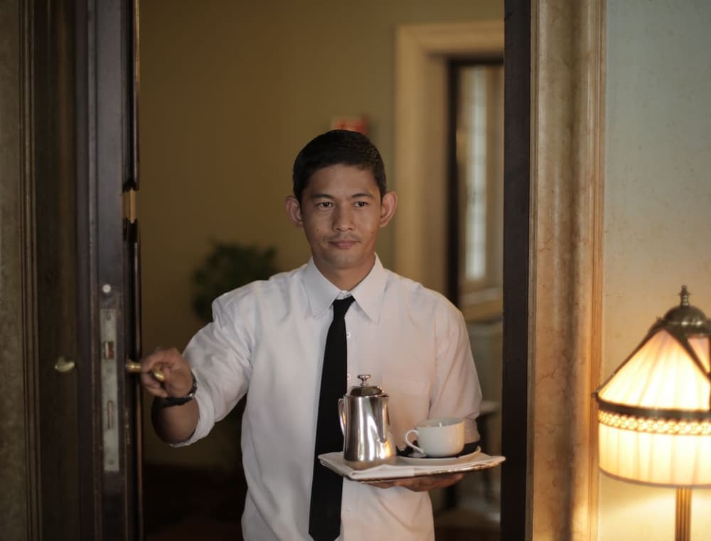 A friendly hospitality worker welcoming a guest